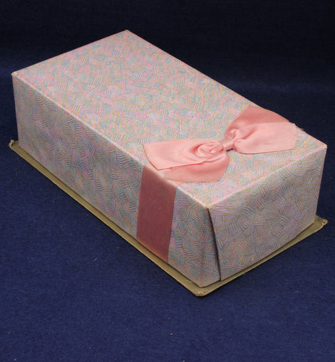 Decorative box with a pink ribbon on a dark blue background