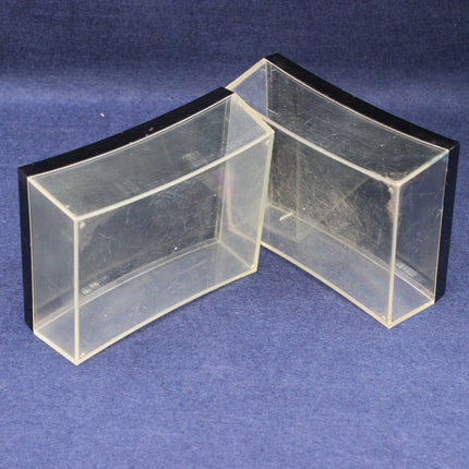 Two clear plastic boxes with black lids on a blue background