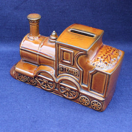 Ceramic train-shaped money box with 'St. Louis' on a blue background