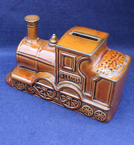 Ceramic train-shaped money box with 'St. Louis' on a blue background