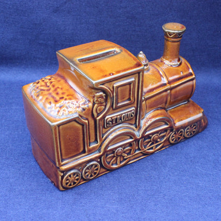 Ceramic train-shaped piggy bank with 'St. Louis' on a blue background