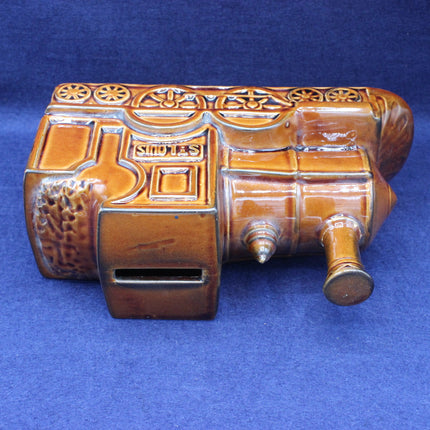 Decorative brown money box with intricate patterns on a blue background