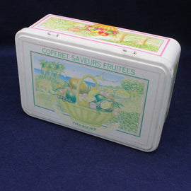 Decorative tin box with fruit-themed design on a dark background