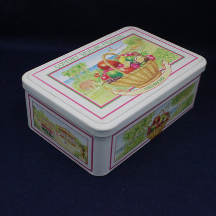 Decorative tin box with fruit basket design on a dark background