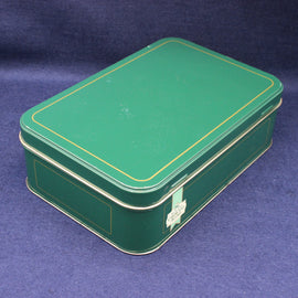 Green metal box with gold trim on a blue background