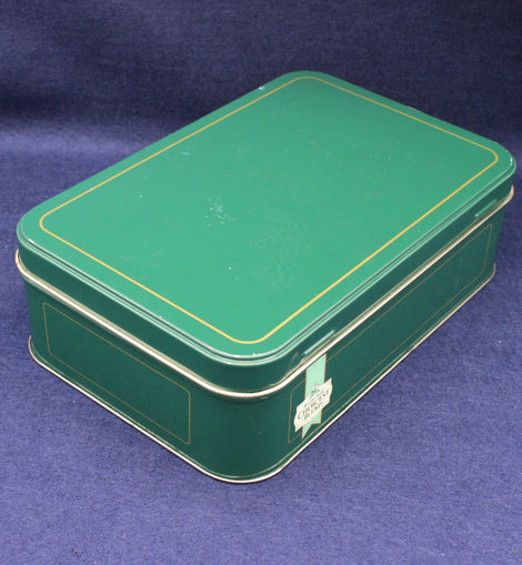 Green metal box with gold trim on a blue background