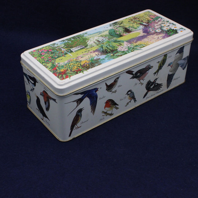 Rectangular tin box with bird illustrations on a dark background