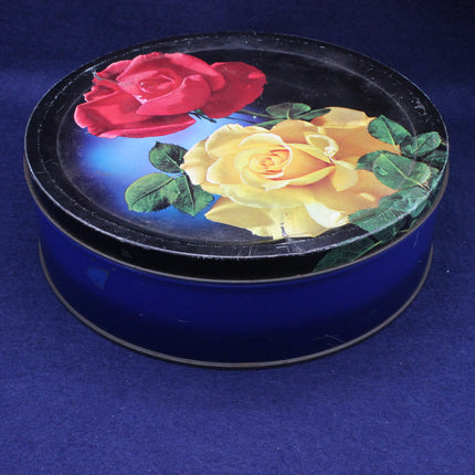 Round blue container with a lid featuring red and yellow roses on a blue background