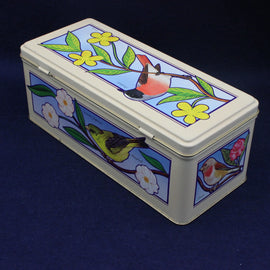 Decorative tin box with bird and floral design on a dark blue background