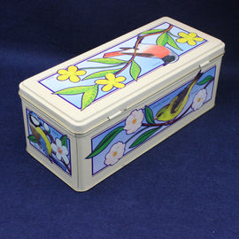 Decorative tin box with bird and flower design on a blue background