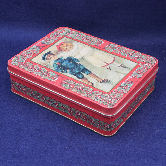 Decorative red tin box with a printed design on a blue background