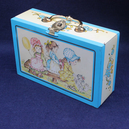 Decorative tin with illustrations of children and flowers on a blue background