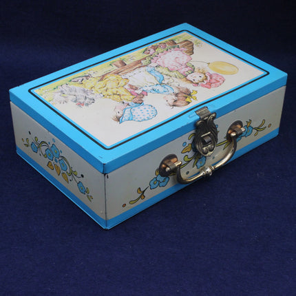Decorative tin box with a colorful lid featuring cartoon characters on a blue background.