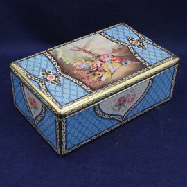 Decorative tin biscuit box with intricate design and painting on a blue background