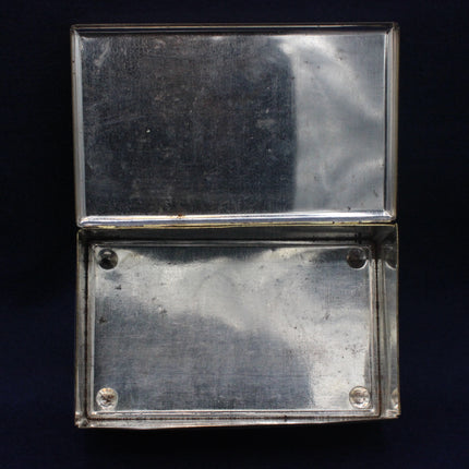 Silver rectangular object with a reflective surface on a black background