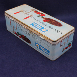Vintage tin box with branding and product illustration on a dark blue background