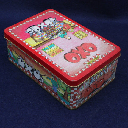 Colorful tin box with cartoon designs and 'Oxo' branding on a dark blue background