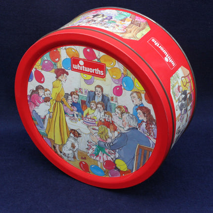 Round Whitworths cookie tin with colorful illustrations on a blue background