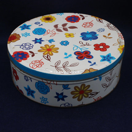 Round tin with colorful floral pattern on a black background