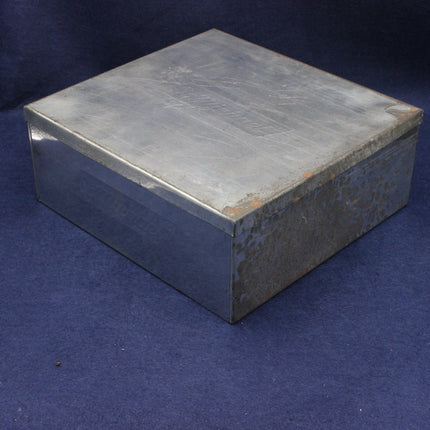 Metallic square biscuit tin on a blue background