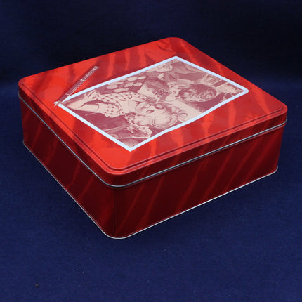 Red tin box with a vintage-style illustration on a dark blue background