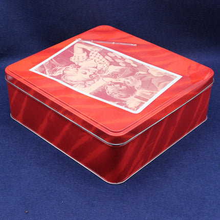 Red tin box with a decorative lid on a blue background
