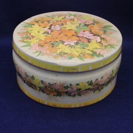 Round tin box with floral design on a blue background