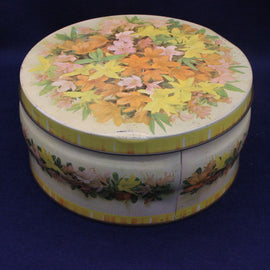 Round floral tin box with a colorful design on a dark blue background