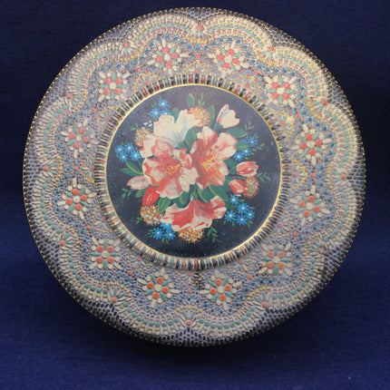 Decorative tin with floral design and beadwork on a blue background