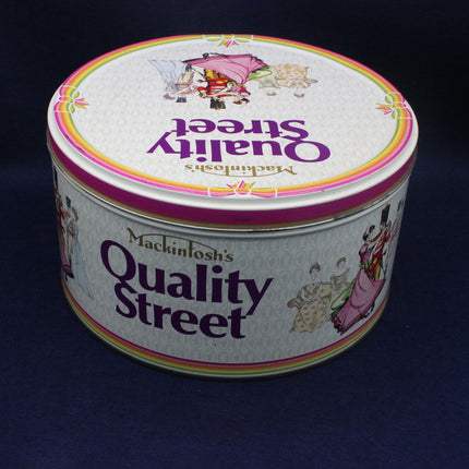 Round tin of Quality Street Mackintosh's on a dark background