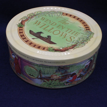 Round tin container with 'The Wind in the Willows' design on a dark background