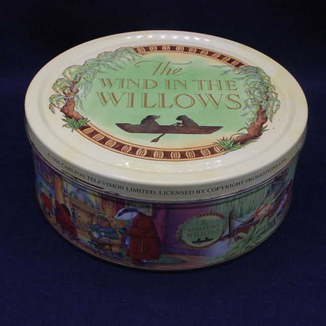 Round tin container with 'The Wind in the Willows' design on a dark background