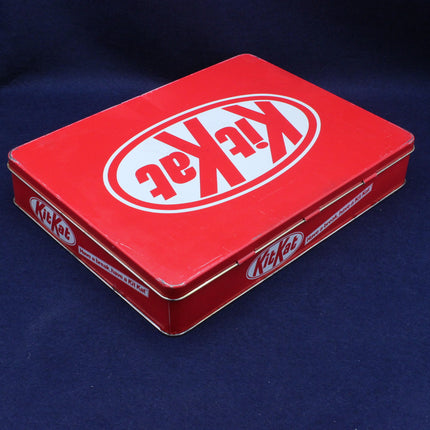 Red KitKat chocolate bar tin on a dark blue background