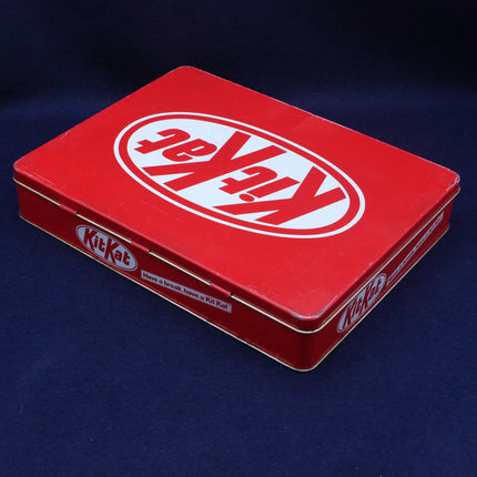 Red KitKat chocolate bar packaging box on a dark blue background