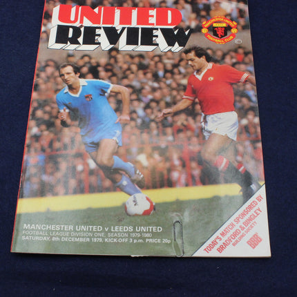 Soccer match program cover featuring two players and text about a match between Manchester United and Leeds United.