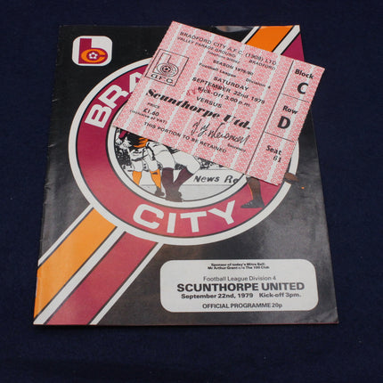 Football match programme with a ticket on top against a dark background