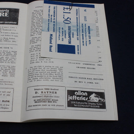 Open book with text and advertisements on a black background