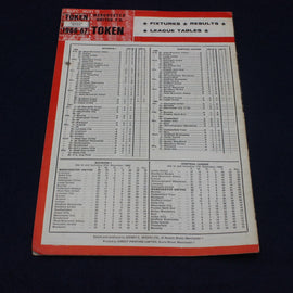 Vintage sports league table book with red and white cover on a black background