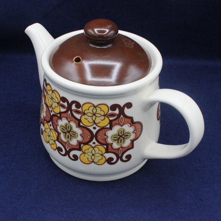 Ceramic teapot with floral pattern on a blue background