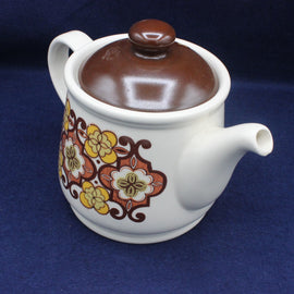 Ceramic teapot with floral design on a blue background