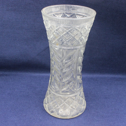 Clear glass vase with intricate patterns on a blue background