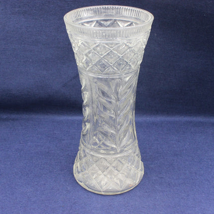 Clear glass vase with intricate patterns on a blue background