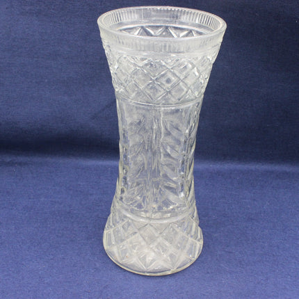 Clear glass vase with diamond cut pattern on a blue background