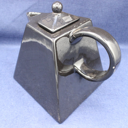 Black Vintage teapot-shaped object on a blue background