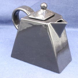 Black square shaped teapot on a light blue background