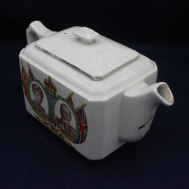 White teapot with decorative elements on a dark background