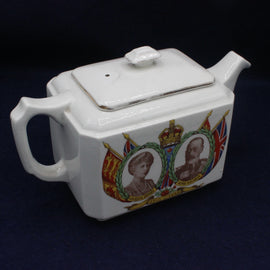 White teapot with royal portraits and flags on a dark background