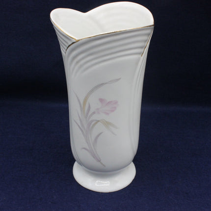 White ceramic vase with floral design on a dark blue background