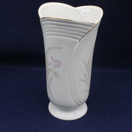 Gray ceramic vase with floral design on a dark blue background