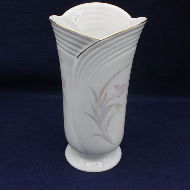 White ceramic vase with floral patterns on a dark blue background